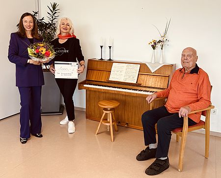 Pflege-Einrichtungsleiterin Elisabeth Hein nimmt Klavier-Spende von Familie Donner entgegen.